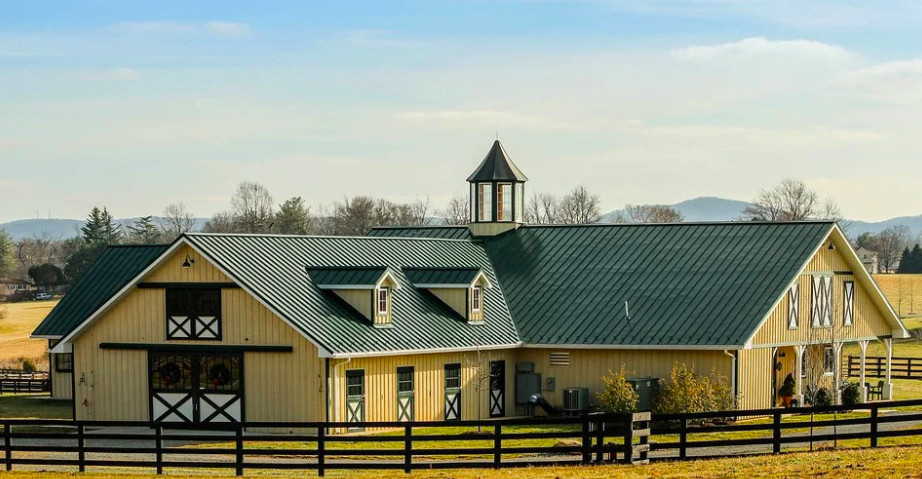 Beautiful Horse stable, with grass and fencing around.