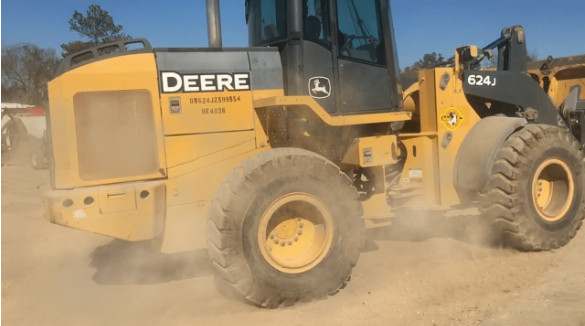 Dust getting kicked up and spread into the air by equipment tires and use.